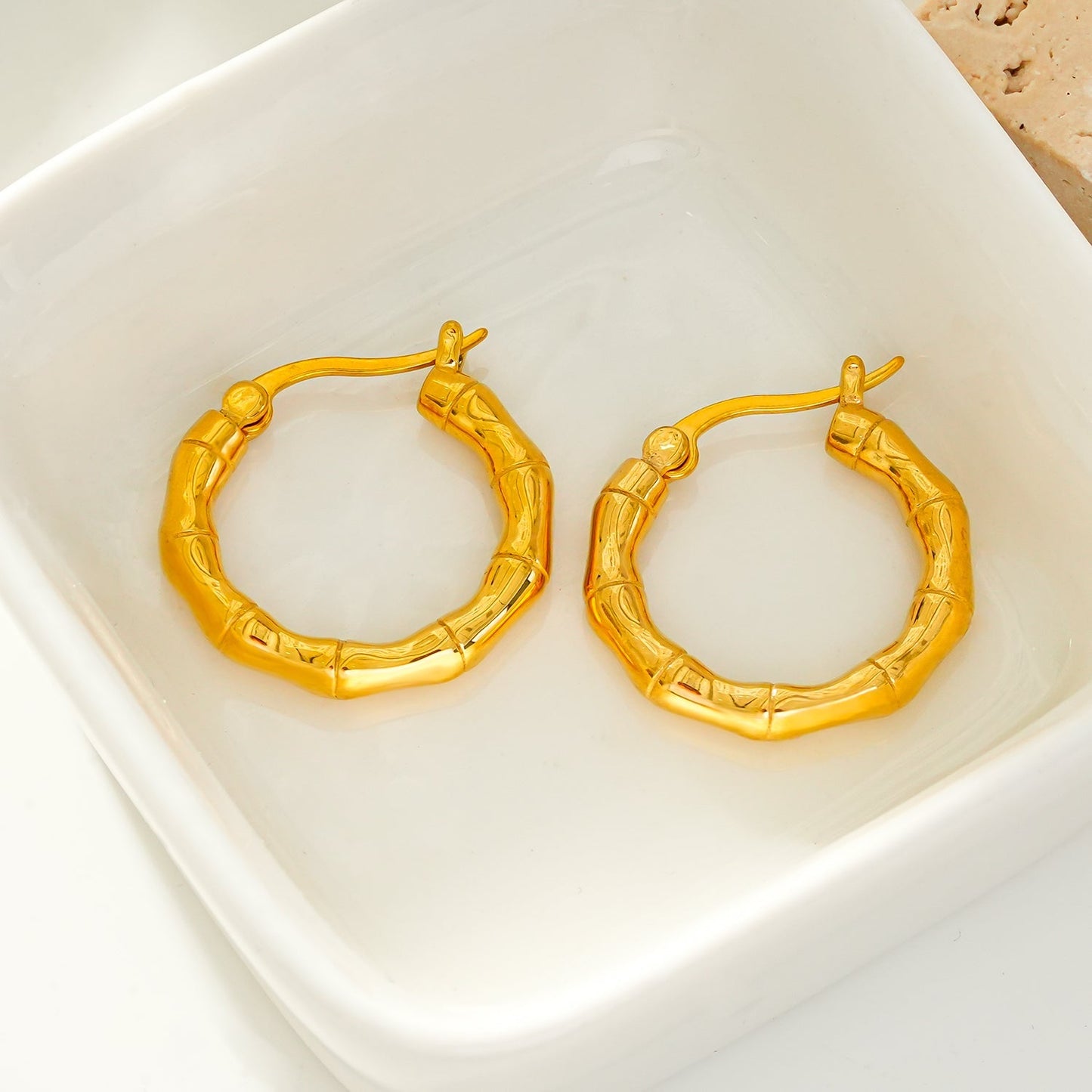 METIOS: Bamboo Textured Hoop Earrings in Gold - Velora Luxury Fashion